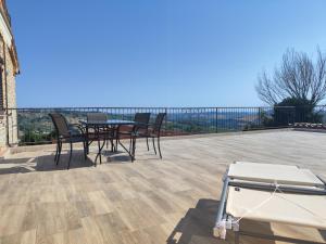 a patio with a table and chairs on a deck at Casale San Martino Agriturismo Bio in SantʼAngelo in Pontano