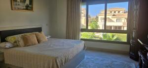 Un dormitorio con una cama y una ventana grande. en Marassi Villa Twinhouse, en El Alamein