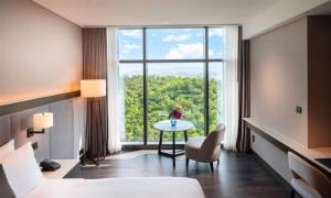 城南市DoubleTree By Hilton Seoul Pangyo的客房设有床、桌子和大窗户。
