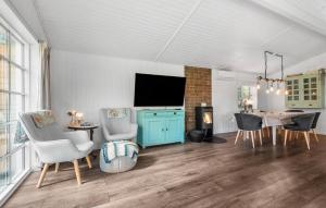 a living room with a tv and a table and chairs at Holiday Home Linningvej in Hemmet