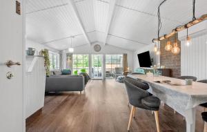 a kitchen and living room with a table and chairs at Holiday Home Linningvej in Hemmet