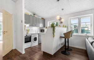 a kitchen with white cabinets and a counter top at Holiday Home Linningvej in Hemmet +16 photos