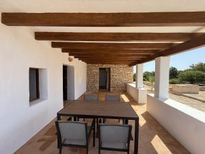 a dining room with a wooden table and chairs at Ca Na Vilda in Sant Ferran de Ses Roques