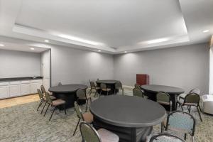 グリーンズボロにあるWingate by Wyndham Greensboro-Coliseumのテーブルと椅子とスクリーンを備えた会議室 +53枚の写真