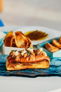 a plate of food with a sandwich on a table at Cala San Miguel Ibiza Resort, Adults only, Curio Collection by Hilton in Puerto de San Miguel +37 photos