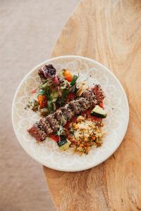a white plate of food on a wooden table at Cala San Miguel Ibiza Resort, Adults only, Curio Collection by Hilton in Puerto de San Miguel