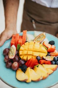 a plate of fruit and vegetables on a table at Cala San Miguel Ibiza Resort, Adults only, Curio Collection by Hilton in Puerto de San Miguel
