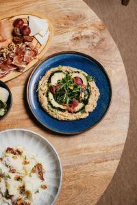 a blue plate with a pizza on a wooden table at Cala San Miguel Ibiza Resort, Adults only, Curio Collection by Hilton in Puerto de San Miguel