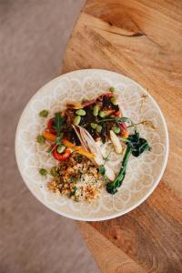 a white plate of food on a wooden table at Cala San Miguel Ibiza Resort, Adults only, Curio Collection by Hilton in Puerto de San Miguel