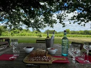 a wooden table with bottles of wine and food at Bordeaux Castle natural No2 in Quinsac