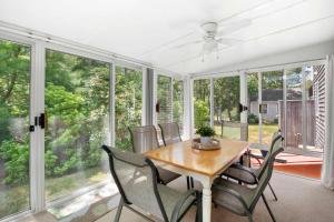 a dining room with a table and chairs and windows at Next to Bike Trail Outdoor Adventure Awaits in Harwich