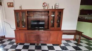 - un centre de divertissement en bois avec une télévision dans la chambre dans l'établissement Maison d'hôtes Villa Mont du Pèlerin à Toamasina Madagascar, à Toamasina