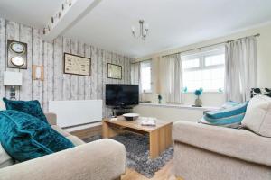 a living room with two couches and a tv at The Penthouse at Beach Court in Trearddur +4 photos