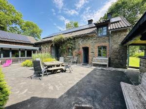 a patio with a table and chairs in front of a building at Les Ecuries du Lac in Weywertz