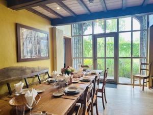 a long wooden table in a room with a large window at Les Ecuries du Lac in Weywertz