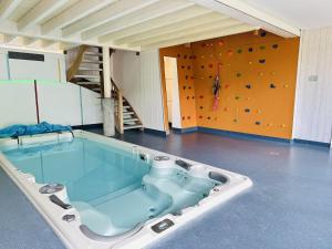 a large tub in a room with a climbing wall at Les Ecuries du Lac in Weywertz