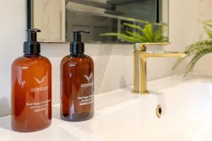 two bottles of soap sitting on a bathroom sink at The Scarborough Suite in Marske