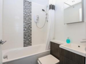 a bathroom with a tub and a toilet and a sink at Cwtch y Môr in Holyhead +20 photos