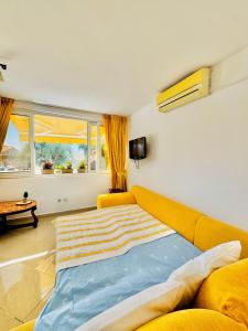 a bedroom with a large bed and a yellow couch at Turkuaz Boutique Hotel in Sveti Stefan
