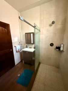 a bathroom with a glass shower and a sink at Baja experience house in Rosarito Beach +30 photos