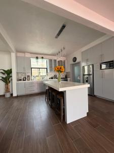 a large kitchen with white cabinets and a large island at Baja experience house in Rosarito Beach