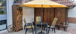 un tavolo e delle sedie sotto un ombrellone in un patio di Fewo Seestern a Bremerhaven Altre 5 foto