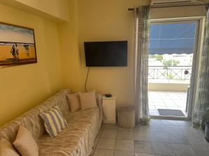 ein Wohnzimmer mit Couch und Flachbildfernseher in der Unterkunft Sunnyhomes Ipsilantou in Loutraki
