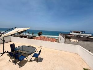 a patio with a table and chairs and the ocean at Baja experience house in Rosarito Beach