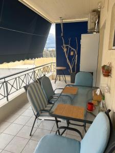 eine Terrasse mit Tisch und Stühlen auf einem Balkon in der Unterkunft Sunnyhomes Ipsilantou in Loutraki