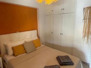 ein Schlafzimmer mit einem Bett mit gelben Kissen darauf in der Unterkunft Sunnyhomes Ipsilantou in Loutraki