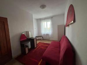 a living room with a red couch and a mirror at Weinesya Sunset Smida in Beliş