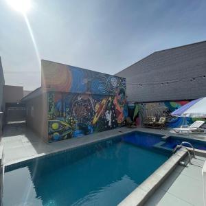 a swimming pool with a mural on the side of a building at Resenha Social Fest in Itapetininga +5 photos