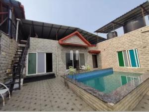a house with a swimming pool next to a building at Luxury villa in Mumbai