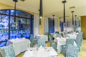 a restaurant with white tables and chairs and a window at SoloApartment in Sunny Beach
