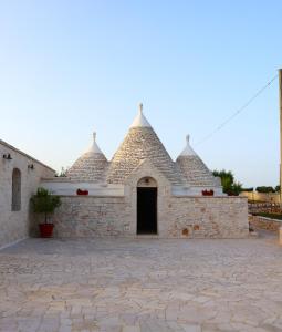 a stone building with a door in a courtyard at Dimora Sasa in Putignano +34 photos