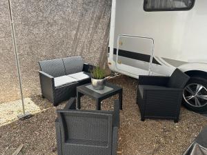un patio con sedie, un tavolo e un rimorchio di Gitanos a Rodilhan