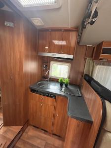 una cucina in un camper con armadi in legno e lavandino di Gitanos a Rodilhan