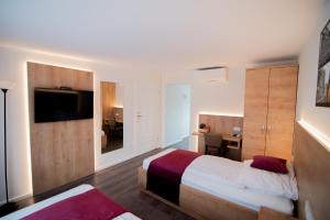 a hotel room with two beds and a television at Apartamenty Polonia Mrągowo in Mrągowo +37 photos