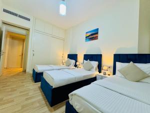 a hotel room with two beds with blue accents at VIP Residence - Exclusively for Ladies in Dubai