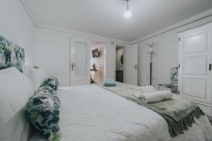 ein weißes Schlafzimmer mit einem großen Bett mit Kissen darauf in der Unterkunft Casa Milita in São João da Pesqueira