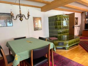 a dining room with a green table and chairs at Casa Walser Quarten - CharmingStay in Quarten