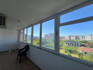 a room with windows with a chair and a view at Hotel Besniku in Shëngjin