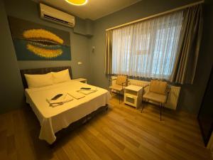 イスタンブールにあるArmoni City Otel Kadıköyのベッドとテーブルと椅子のある寝室