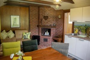 a kitchen and living room with a brick fireplace at Waldsaumhütte mit Ausblick in Pirna