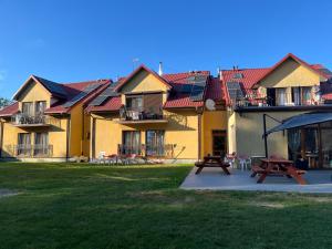 a large building with red roofs and a picnic table at Pokoje Alina, 500m do morza ze śniadaniem in Grzybowo