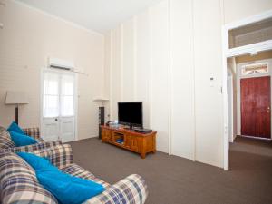 a living room with a couch and a television at CBD Holiday Home in Mackay