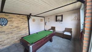 a room with a pool table in a garage at Domek parterowy apartamentowy Ostoja in Rewal