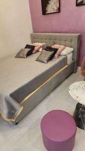 a bed in a room with a purple wall at Ultra Central White & Lila Studio in Bucharest