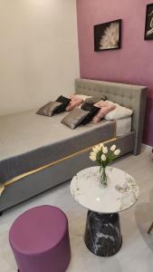 a room with a bed and a table and a table sidx sidx sidx at Ultra Central White & Lila Studio in Bucharest