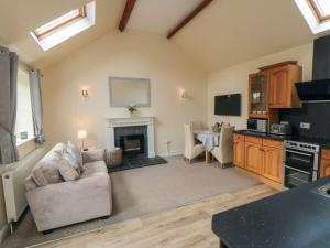 un salon avec un canapé et une cheminée dans l'établissement Midsummer Cottage, à Wilton
